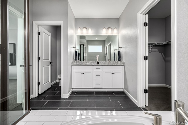 9406 Bross St, Arvada, CO 80007 - full bathroom with vanity, a spacious closet, and tile patterned flooring