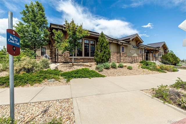 9406 Bross St, Arvada, CO 80007 - view of front facade with stone siding, a standing seam roof, board and batten siding, and a metal roof