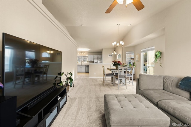 carpeted living room featuring ceiling fan with notable chandelier and vaulted ceiling