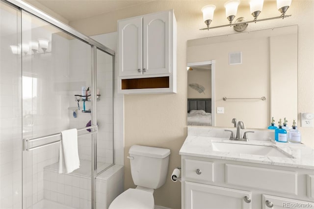 bathroom with vanity, a shower with shower door, and toilet