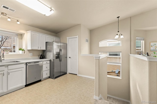 1431 Madison Ridge Hts Unit D, Colorado Springs, CO 80904 - kitchen with stainless steel appliances, a sink, light flooring, white cabinets, and plenty of natural light