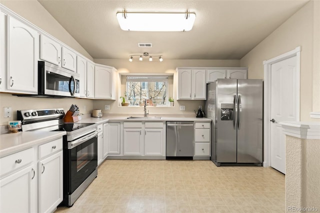 1431 Madison Ridge Hts Unit D, Colorado Springs, CO 80904 - kitchen with appliances with stainless steel finishes, a sink, white cabinetry, light flooring, and lofted ceiling