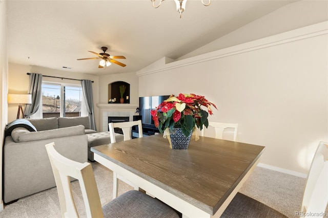 1431 Madison Ridge Hts Unit D, Colorado Springs, CO 80904 - dining area with light colored carpet, a tiled fireplace, ceiling fan, vaulted ceiling, and a chandelier