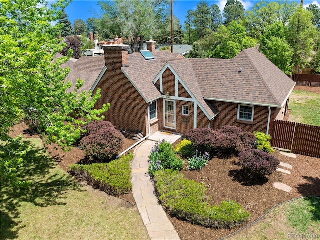 2500 Locust St, Denver, CO 80207 - tudor home featuring fence, roof with shingles, brick siding, and a chimney