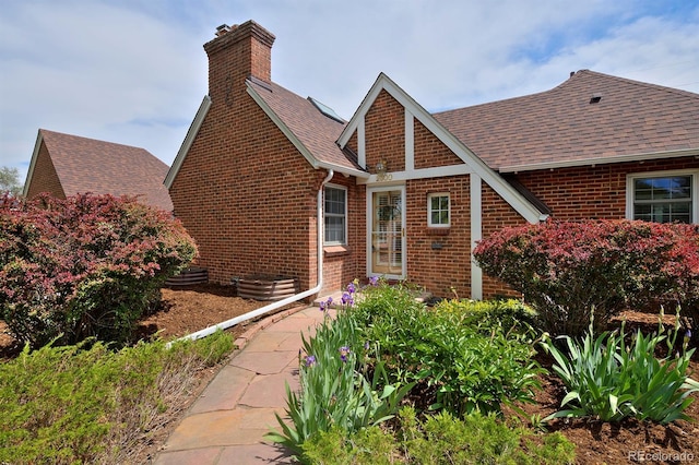 2500 Locust St, Denver, CO 80207 - view of front of home featuring brick siding, a chimney, and roof with shingles