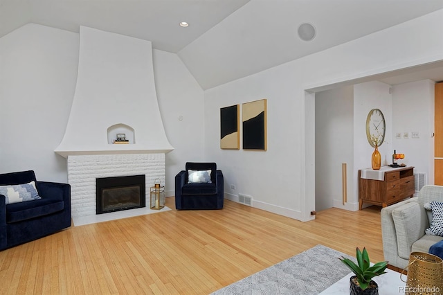 2500 Locust St, Denver, CO 80207 - living area with lofted ceiling, wood finished floors, a brick fireplace, and baseboards