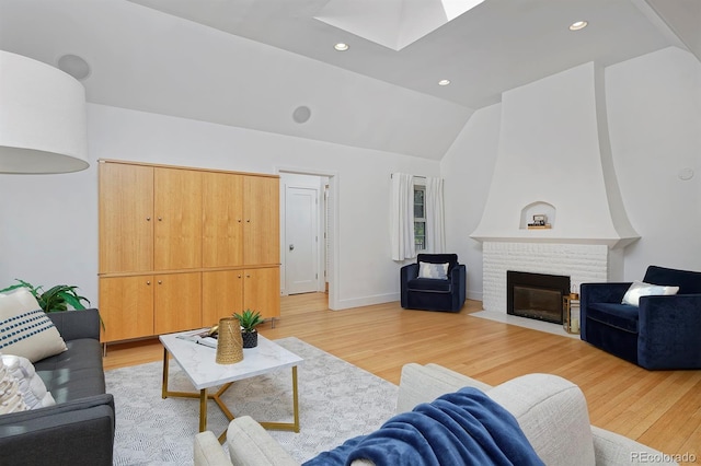 2500 Locust St, Denver, CO 80207 - living room featuring a skylight, light wood-style floors, lofted ceiling, a brick fireplace, and recessed lighting
