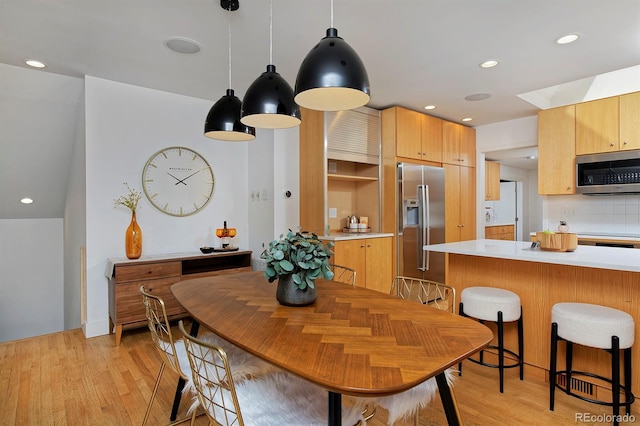 2500 Locust St, Denver, CO 80207 - kitchen featuring stainless steel appliances, light countertops, light wood-style floors, a breakfast bar, and recessed lighting