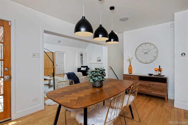 2500 Locust St, Denver, CO 80207 - dining area featuring light wood-type flooring, baseboards, and a brick fireplace
