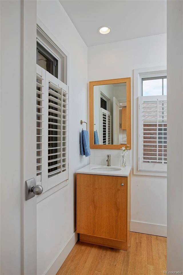 2500 Locust St, Denver, CO 80207 - bathroom featuring wood finished floors, baseboards, vanity, and recessed lighting