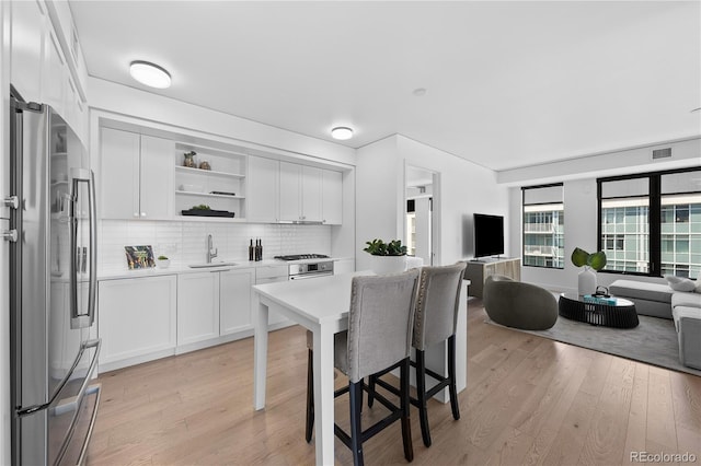 1750 Wewatta St Unit 1301, Denver, CO 80202 - kitchen featuring freestanding refrigerator, a sink, open floor plan, open shelves, and light wood-style floors