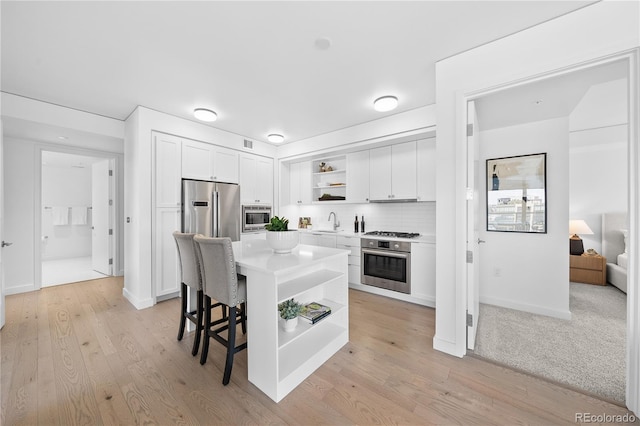 1750 Wewatta St Unit 1301, Denver, CO 80202 - kitchen featuring open shelves, appliances with stainless steel finishes, a sink, and white cabinetry