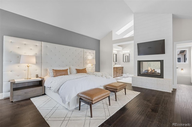 22454 Anasazi Way, Golden, CO 80401 - bedroom featuring wood finished floors, a multi sided fireplace, ensuite bathroom, and high vaulted ceiling