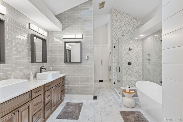 22454 Anasazi Way, Golden, CO 80401 - bathroom featuring tile walls, double vanity, a freestanding tub, a shower stall, and marble look tiles