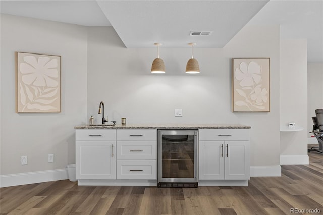 22454 Anasazi Way, Golden, CO 80401 - indoor wet bar featuring wine cooler, dark wood-style flooring, and pendant lighting