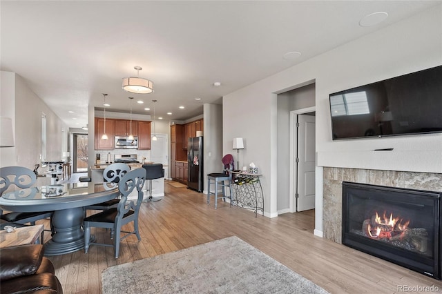 dining area featuring a fireplace and light hardwood / wood-style floors