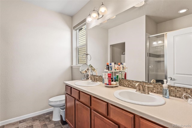 bathroom featuring vanity, toilet, decorative backsplash, and walk in shower