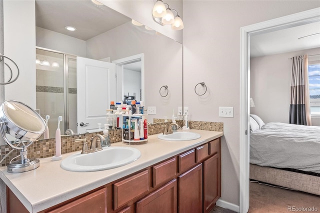 bathroom with vanity, decorative backsplash, and a shower with door