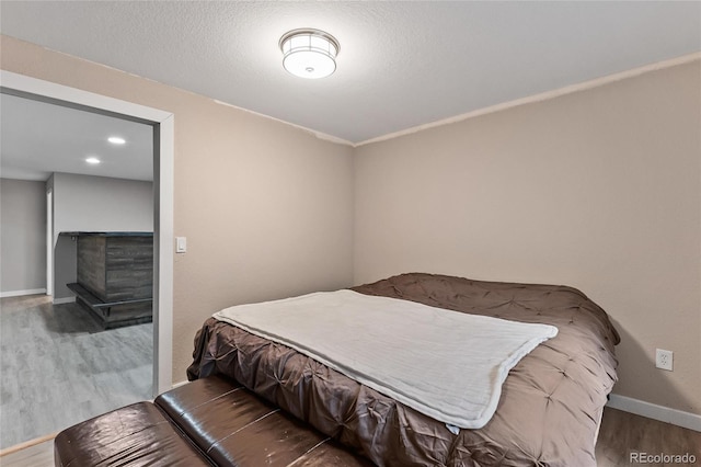 bedroom with hardwood / wood-style floors and a textured ceiling