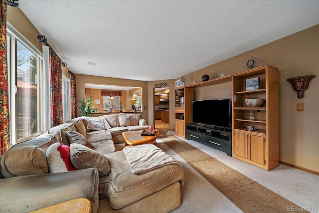 living room featuring a textured ceiling, light colored carpet, and baseboards