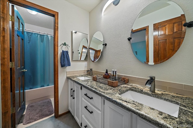 bathroom featuring double vanity, a sink, and shower / tub combo