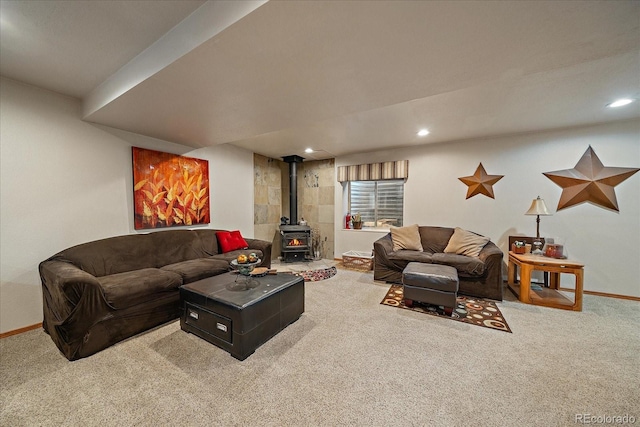 carpeted living area featuring baseboards, a wood stove, and recessed lighting