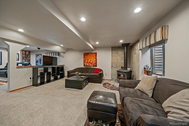 carpeted living area with recessed lighting, baseboards, and a wood stove
