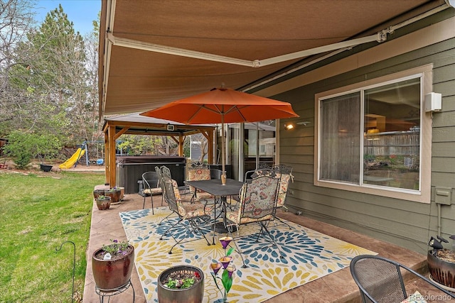 view of patio / terrace with a playground, a hot tub, and outdoor dining space