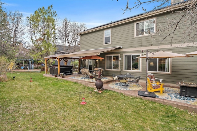 back of property featuring a gazebo, a playground, a patio area, a lawn, and a hot tub