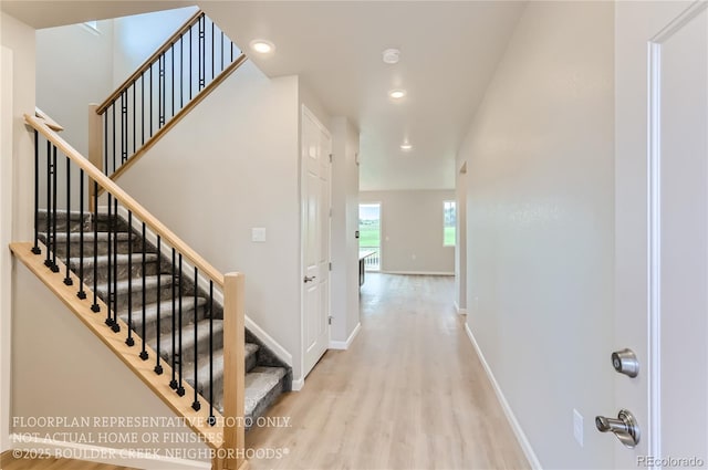 stairs featuring recessed lighting, wood finished floors, and baseboards