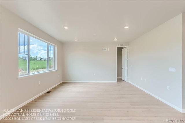 empty room with light wood-type flooring, visible vents, and recessed lighting