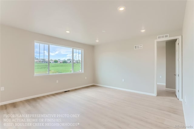 empty room featuring light wood-style flooring, visible vents, and recessed lighting