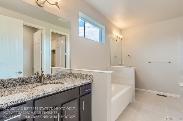 full bath featuring tile patterned floors, vanity, baseboards, and a bath