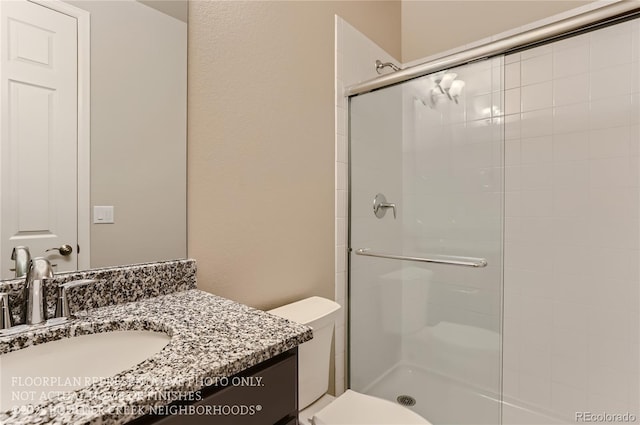 bathroom featuring a stall shower, vanity, and toilet