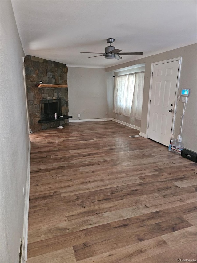 unfurnished living room with a fireplace, hardwood / wood-style floors, and ceiling fan