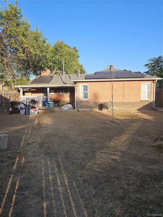 back of house featuring solar panels and a patio area