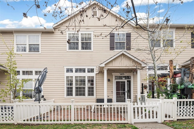 townhome / multi-family property with a fenced front yard and a gate
