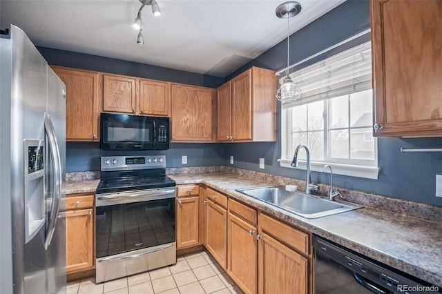 kitchen with black appliances, a sink, decorative light fixtures, light tile patterned flooring, and brown cabinetry