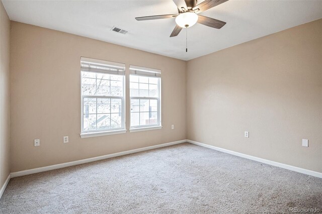 empty room featuring carpet, baseboards, and a ceiling fan