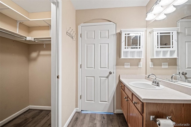 bathroom featuring wood finished floors, vanity, and baseboards