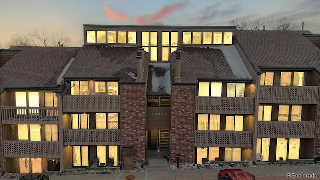 back of house at dusk with brick siding
