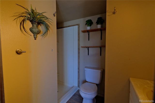 bathroom with toilet, hardwood / wood-style floors, and walk in shower