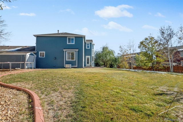 rear view of property with a lawn and central air condition unit