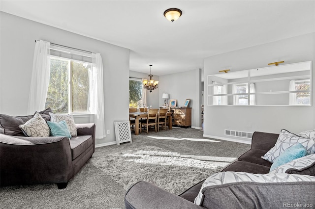 living room featuring carpet flooring and an inviting chandelier