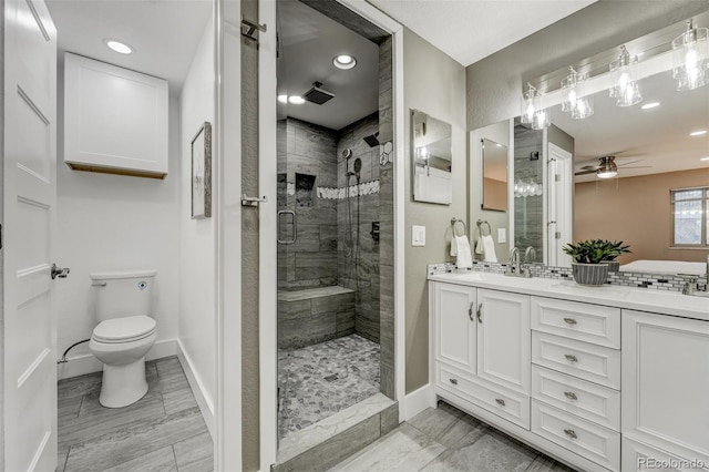 bathroom featuring an enclosed shower, vanity, toilet, and ceiling fan