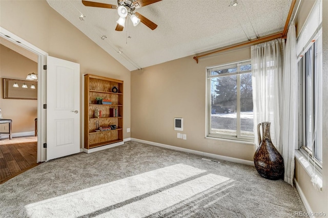 carpeted empty room with high vaulted ceiling and ceiling fan