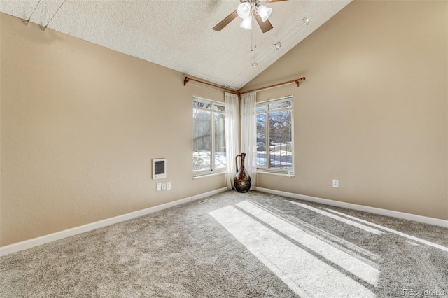 empty room featuring ceiling fan, carpet flooring, high vaulted ceiling, and a textured ceiling