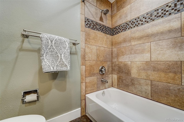 bathroom with tiled shower / bath and toilet