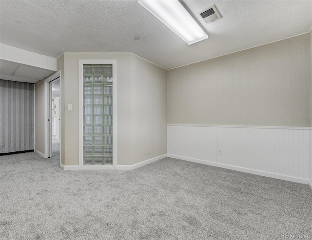 bonus room featuring light carpet and a textured ceiling