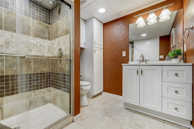 bathroom featuring toilet, an enclosed shower, a paneled ceiling, vanity, and tile patterned flooring